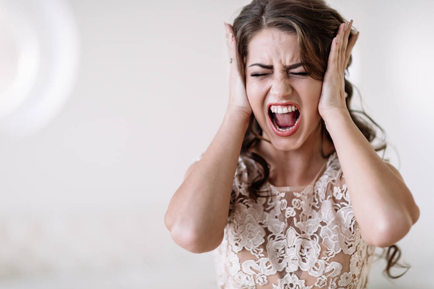 портрет невесты кричит громко закрывая уши руками, в ярости
 - Фото, изображение
