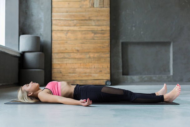 Young woman in yoga class, relax meditation corpse pose - Φωτογραφία, εικόνα