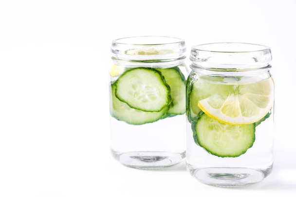 Agua de desintoxicación con pepino y limón aislados sobre fondo blanco
 - Foto, Imagen