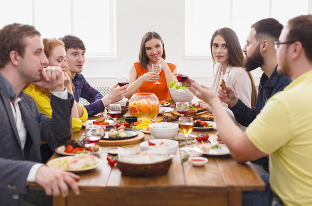 Gruppe fröhlicher Menschen bei festlichem Dinner am Tisch - Foto, Bild