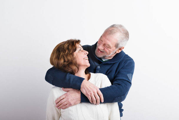 Beautiful senior couple in love hugging. Studio shot. - 写真・画像