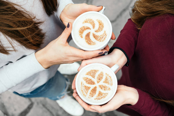 Freunde trinken Kaffee in einem Café-Restaurant - das Konzept eines freundlichen Geschäftstreffens mit modischen Milchgetränken. Cappuccino von oben - Foto, Bild