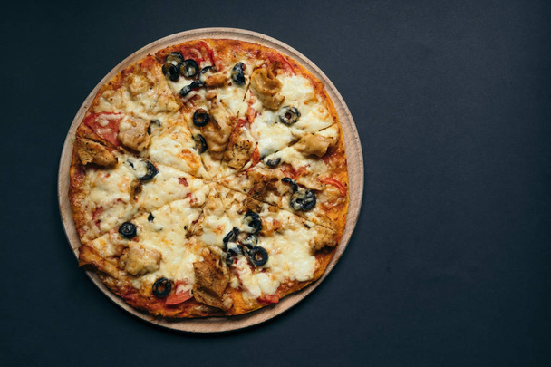 Pizza casera con tomates, mozzarella y albahaca. Vista superior con espacio de copia en la mesa de piedra oscura
 - Foto, imagen