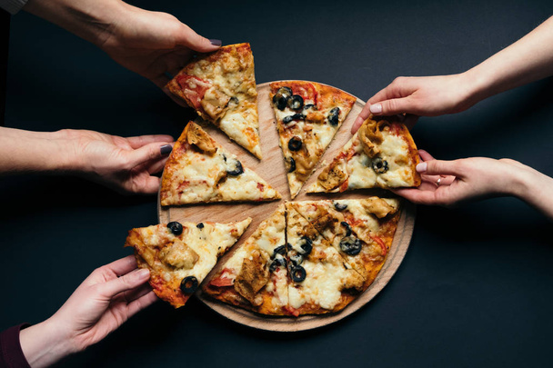 amigos grupo de pessoas que tomam fatias de pizza
 - Foto, Imagem