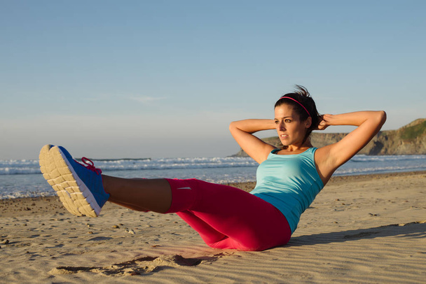 Fitness woman training core with knee raises exercise - Valokuva, kuva