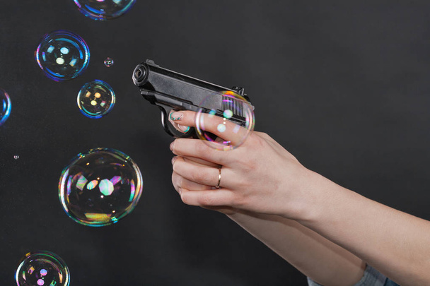 donne caucasiche braccia in possesso di una pistola contro sfondo nero
 - Foto, immagini