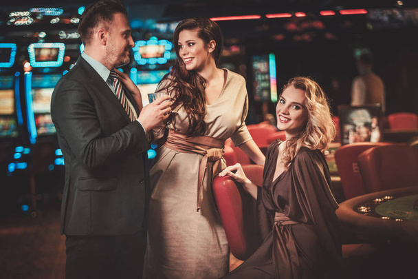 gut gekleidete Freunde in einem luxuriösen Casino-Interieur - Foto, Bild
