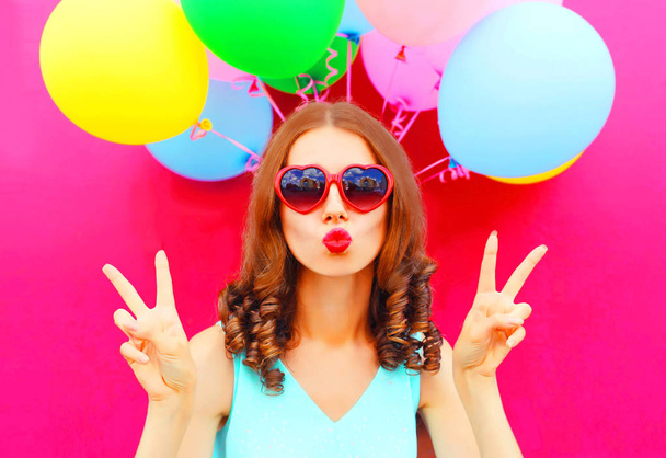 Fashion portrait woman blowing lips holds an air colorful balloo - Фото, изображение