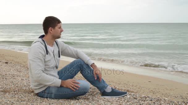 Un uomo riflette sulla spiaggia. Un uomo pensa sulla spiaggia. Ricordi, riflessioni, solitudine
. - Filmati, video