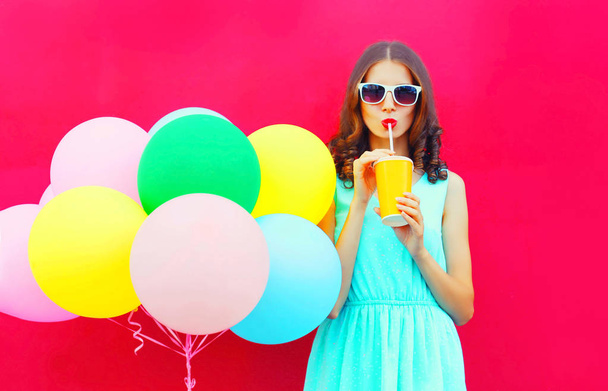 Šťastná žena pije ovocné šťávy z poháru s barevné balónky vzduchem - Fotografie, Obrázek