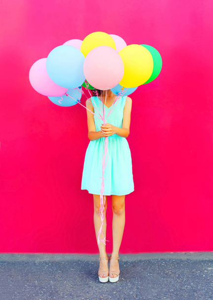 Happy woman is hides her head an air colorful balloons having fu - Фото, изображение