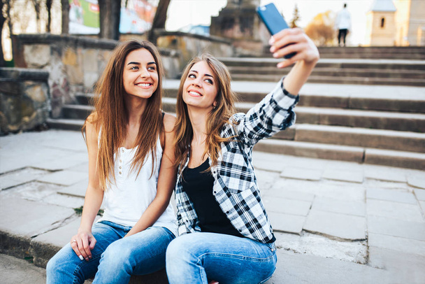 Two pretty girls making selfie  - 写真・画像