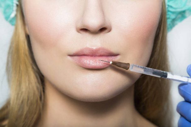 Doctor aesthetician makes lips correction and augmentation to female patient - Fotoğraf, Görsel