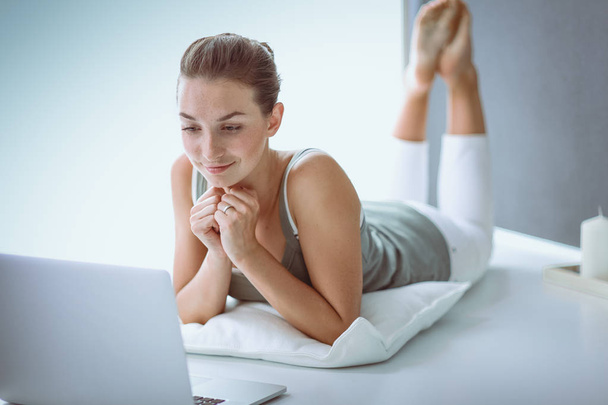 Attractive caucasian girl lying on floor with laptop - Photo, Image