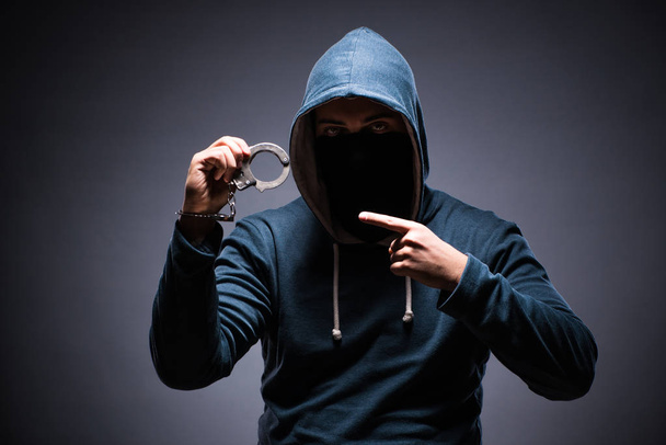 Man wearing hood in dark room - Photo, Image