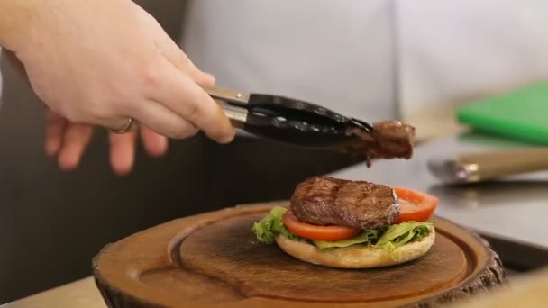 Chef puts meat on a burger bread - Πλάνα, βίντεο