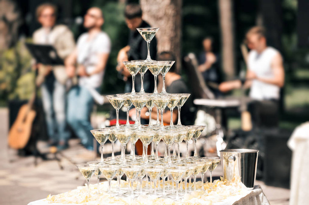 Piramide di champagne su evento, festa o banchetto. ciliegia nel bicchiere. la banda sullo sfondo
 - Foto, immagini