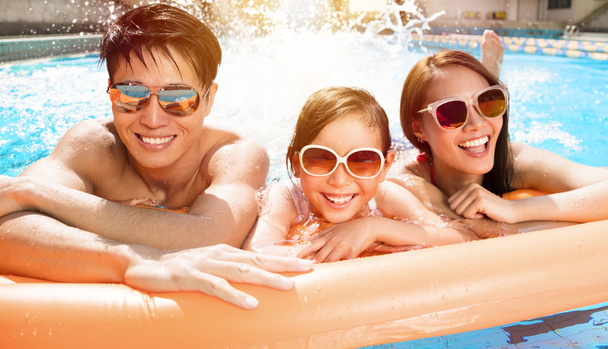 Happy family playing in swimming pool - Photo, Image