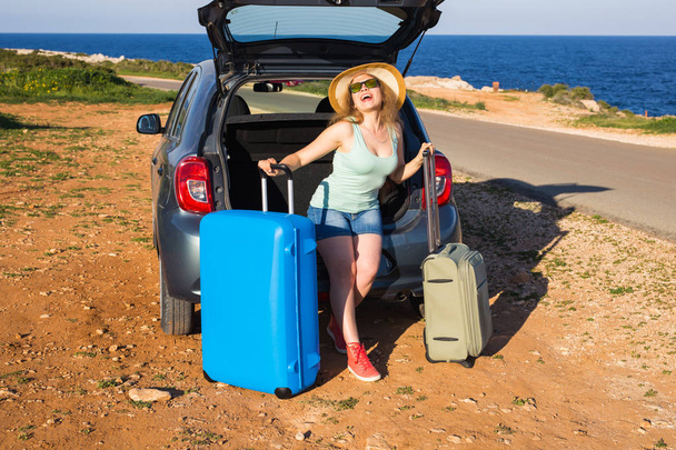 旅行、夏の休日や休暇コンセプト - 車の旅行でスーツケースを持つ若い女性. - 写真・画像