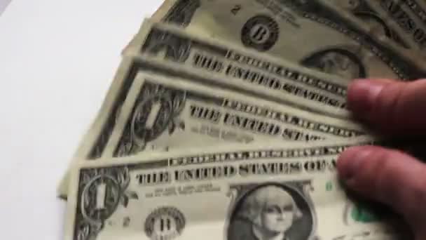Nő a countslot a kis dollár számlák, az asztalon, a fehér háttér makró közelről - Felvétel, videó