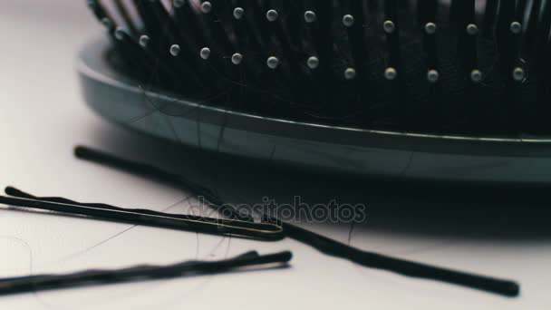 Kobiet grzebień włosy, szczotka do włosów z włosów ekstremalnych makro z bliska widokiem, w pobliżu spinki do włosów czarny - Materiał filmowy, wideo