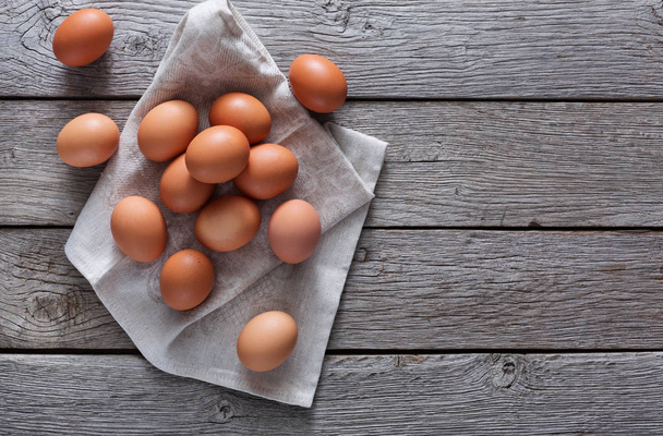 Verse kip bruine eieren op linnen, biologische landbouw achtergrond - Foto, afbeelding
