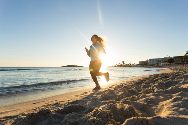 молодые здоровый образ жизни фитнес-женщина работает на пляже восхода солнца
 - Фото, изображение