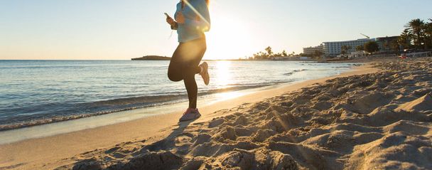 Фитнес-женщина, бегущая на пляже восхода солнца
 - Фото, изображение
