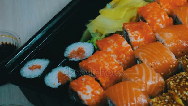 Somon maki rulo. Japon suşi mutfağı taze çiğ balık ile. Soya Japon yemek pirinç, somon veya ton balığı, karides ve balık yumurta oluşan batırılmış - Video, Çekim
