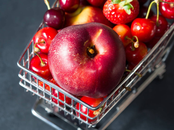 Chariot de supermarché fruits rouges frais sur noir
 - Photo, image