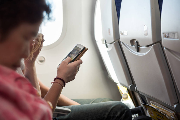 Elini, hava uçak içinde otururken cep telefonu tut - Fotoğraf, Görsel