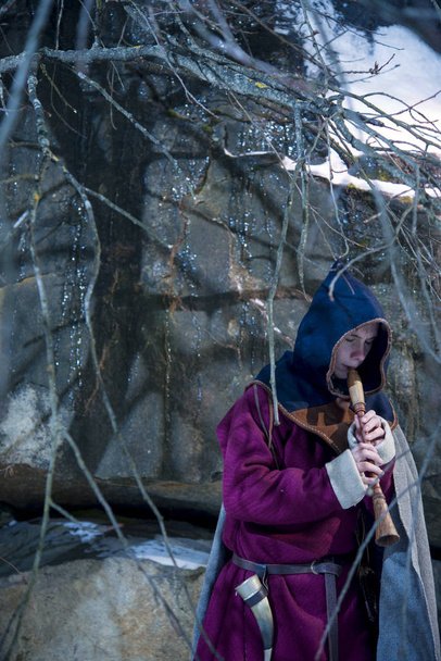 Chlap ve středověkém kostýmu s kapucí hrát na trubku, i v zimě - Fotografie, Obrázek