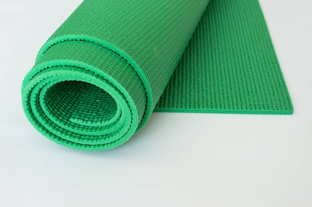 Tapis de yoga vert sur fond blanc
. - Photo, image