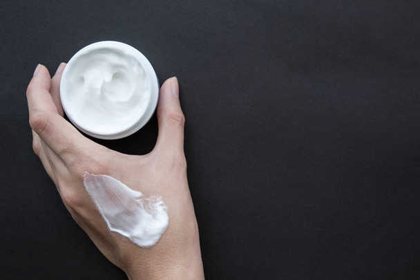 Cream for face or body in female hand. Smear cream on hand - Photo, Image