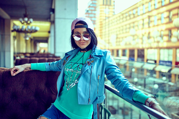 Woman wearing sunglasses and a blue coat . - Fotoğraf, Görsel