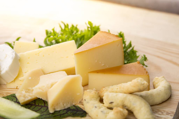 Ahşap bir masa tepside peynir seçimi - Fotoğraf, Görsel