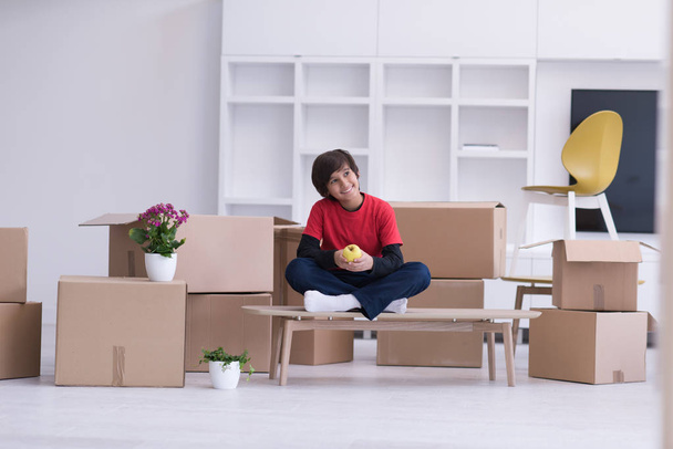 boy sitting on the table with cardboard boxes around him - Φωτογραφία, εικόνα