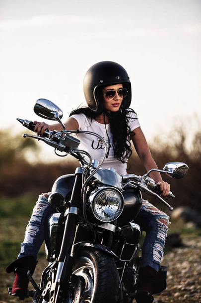 Beautiful motorcycle brunette woman with a classic motorcycle (c - Photo, Image