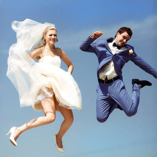 Couple jumps in the sky in the wedding day - Фото, зображення