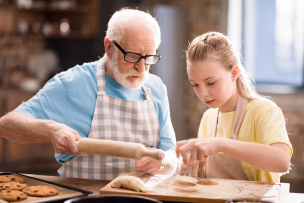grand-père et petite-fille faire de la pâte
 - Photo, image