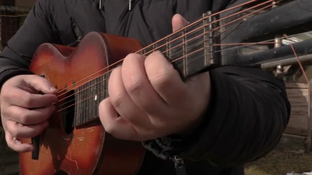 Ο άνθρωπος εξάσκηση να παίξει την κιθάρα στη θερινή ημέρα - Πλάνα, βίντεο