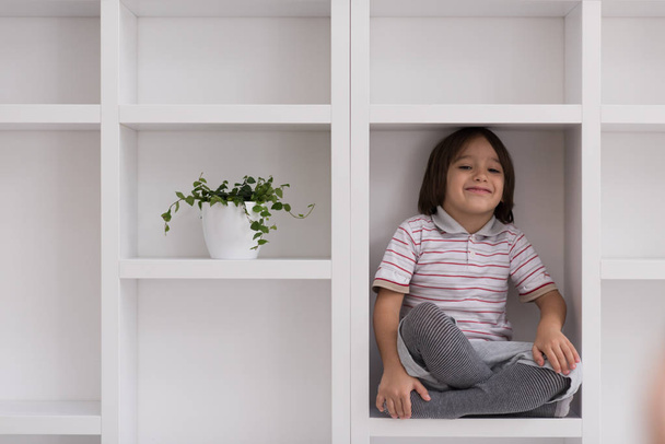 young boy posing on a shelf - Photo, image