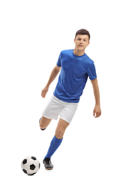 Teenage soccer player kicking a football - Foto, afbeelding