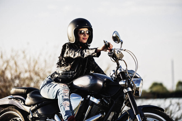 Όμορφη μοτοσυκλέτα μελαχρινή γυναίκα με μια μοτοσικλέτα κλασικό (c - Φωτογραφία, εικόνα
