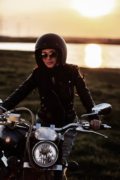 Beautiful motorcycle brunette woman with a classic motorcycle (c - Photo, Image