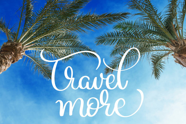 Two palm treetops against a sunny sky and Travel more text. Calligraphy lettering hand draw - Fotó, kép