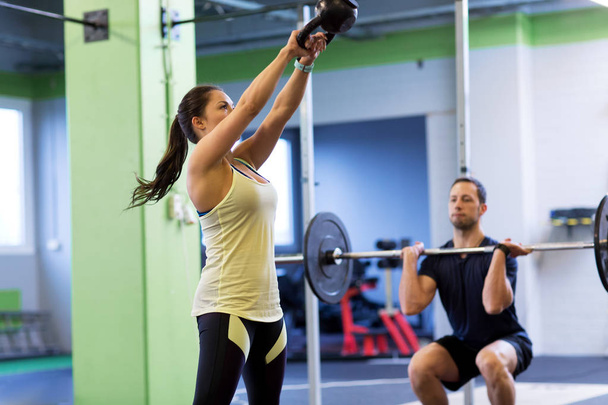 man and woman with weights exercising in gym - Foto, Imagem