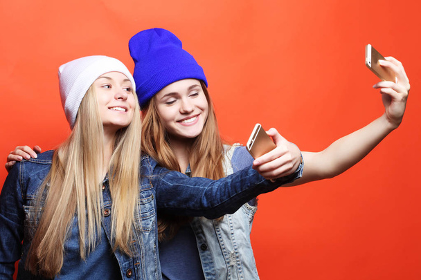 Two teenage girls friends in hipster outfit make selfie on a pho - Fotó, kép