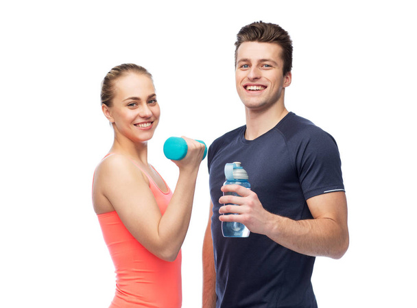 sportive man and woman with dumbbell and water - Foto, Imagem