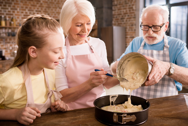 abuelos y niña cocinar juntos
 - Foto, Imagen
